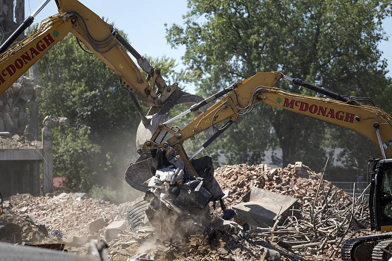 Excavator operators dig up rubble Wednesday, Aug. 21, 2024, at the Micro building demolition site.