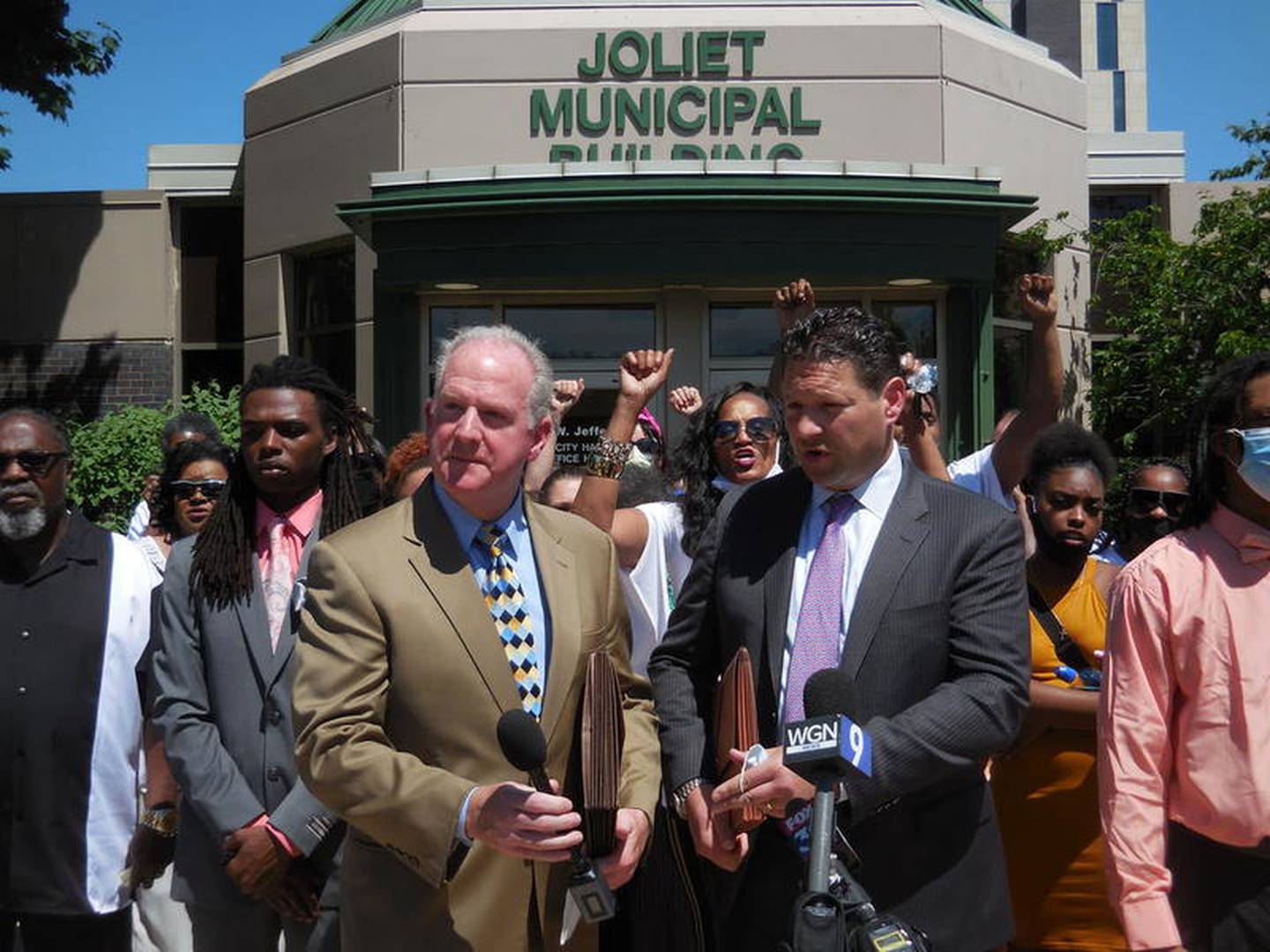 Attorneys Lawrence X. O'Reilly (left) and Michael E. Baker stand in the foreground at a press conference outside Joliet City Hall Monday.