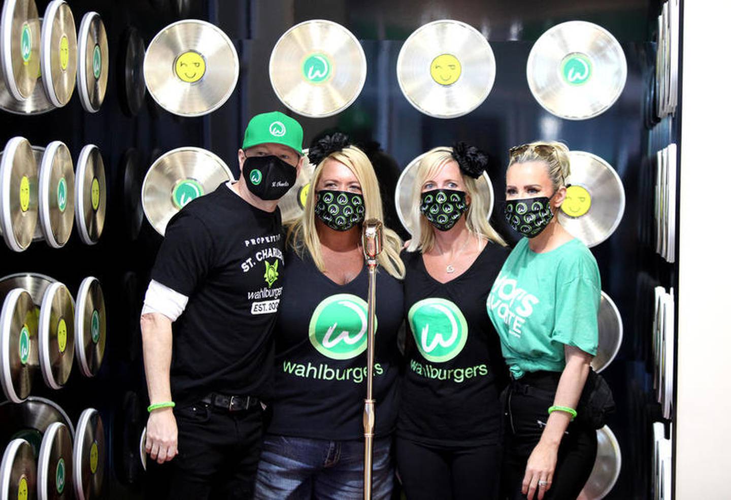Donnie Wahlberg (left) and Jenny McCarthy (right) pose with sisters Michelle Greybill (second from left) and Chrissie Butkus (second from right) at the opening of Wahlburgers in St. Charles on July 28.