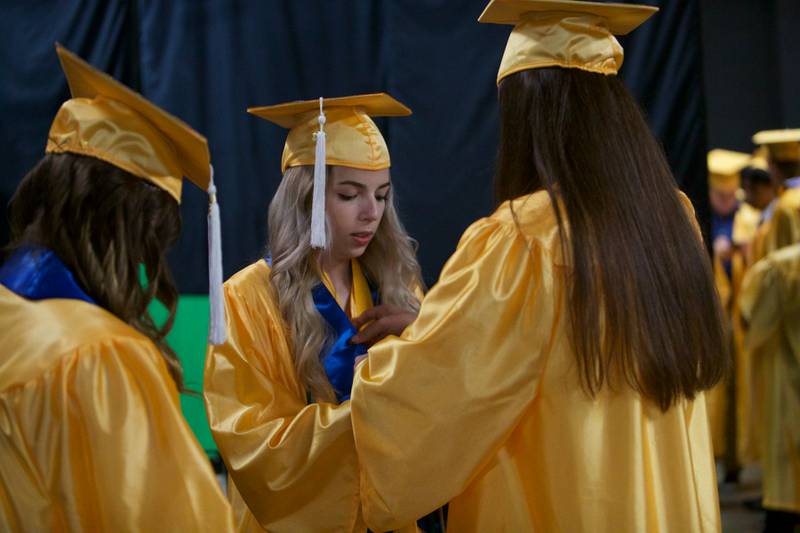 Seniors help each get ready before the Jacobs High School graduation ceremony on May 21, 2022, at the NOW Arena in Hoffman Estates.
