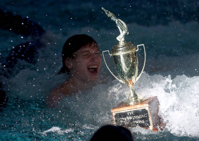Swimmers from Cary-Grove co-op celebrate with the trophy after winning the Fox Valley Conference Swimming Championships at Woodstock North High School Saturday.