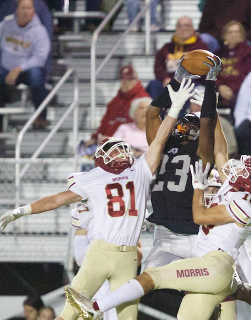 Kaneland's Aric Johnson makes the catch against Morris Bryce Varner (81) and Sam Mateski (10) on Friday, Sept. 8, 2023 in Maple Park.