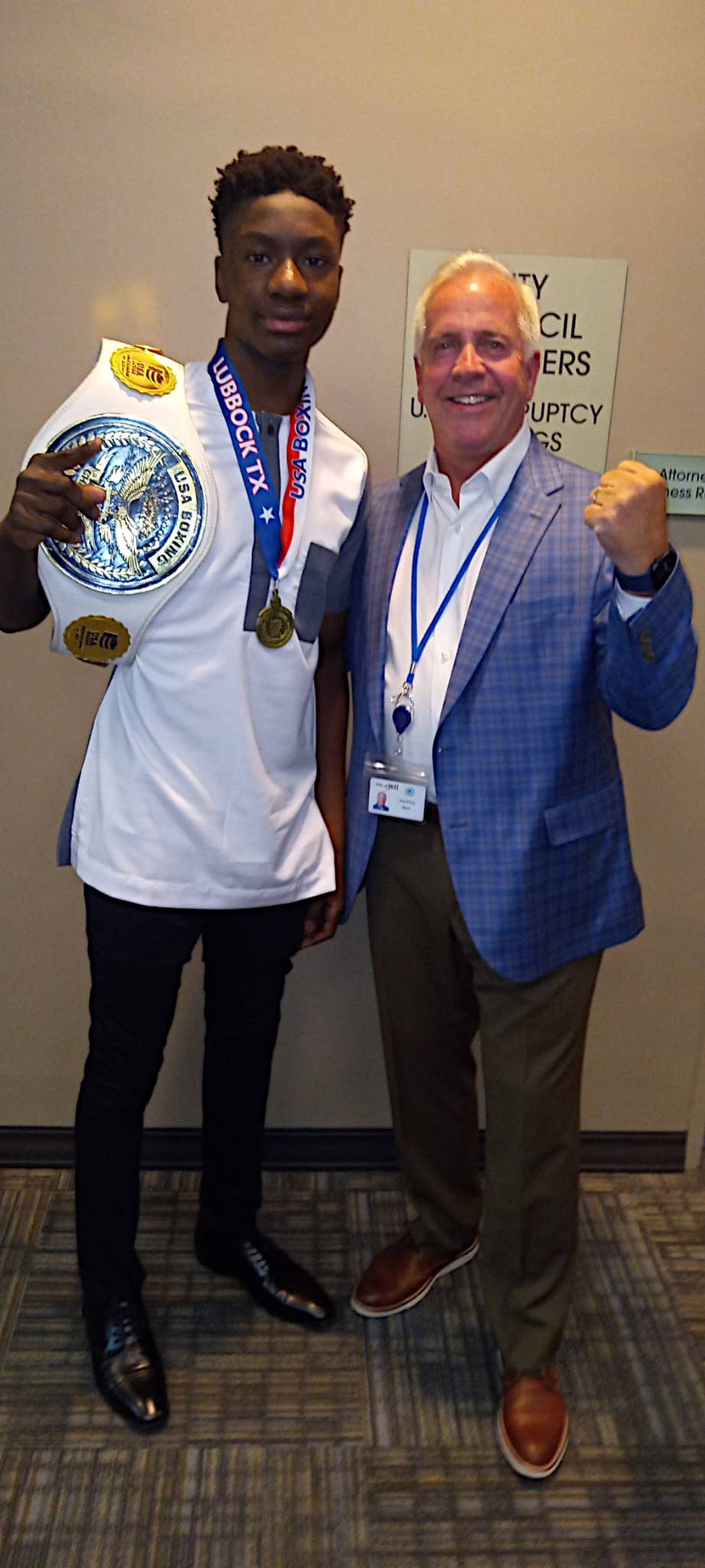 JoJo Awinongya (left) shows off a recent belt and medal to Joliet Mayor Terry D'Arcy.