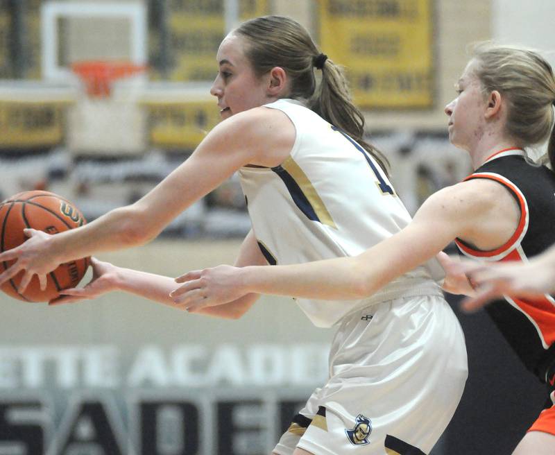 Marquette's Lilly Craig (12) passes as Gardner-South Wilmington's Eva Henderson defends at Bader Gym during the play-in game of the Class 1A Marquette Regional contested Saturday, Feb. 10, 2024.