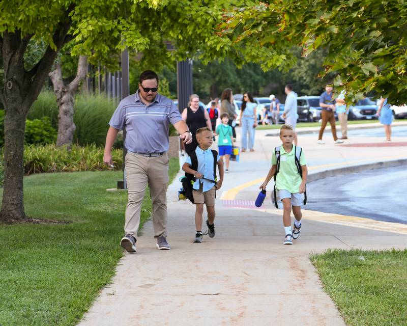 Jason Rogers (left) walks with his kids Kellen, 6, and JJ, 8, during the first day of school on Thursday Aug. 21, 2025, at Western Avenue Elementary in Geneva.