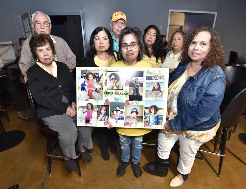 Elgin resident Yolanda Alejandro holds a collage of photos of her niece, Layla Salazar, as she poses with other family members at a fundraiser Friday at Mi Vallarta restaurant in South Elgin. The fundraiser is intended to help Layla's parents, Vinnie and Melinda Salazar, who moved from Elgin to Uvalde, Texas, in 2011.