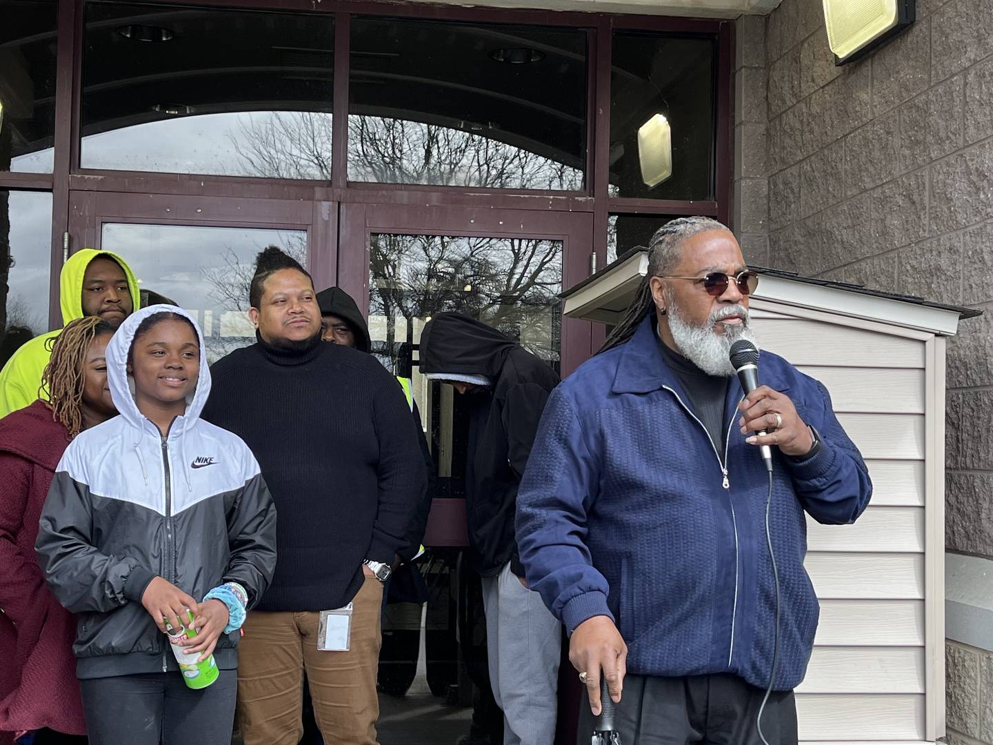 Bishop Steven Evans, of Leap Of Faith Ministries, (right), speaks on Thursday, April 4, outside the Ozzie and Peggy Mitchell Center in Joliet.