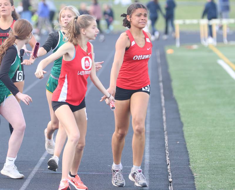 Ottawa's Makenzie Blazys gets the baton from Jazmine Adams in the 4x800 meter relay during the Class 2A Sectional track meet on Wednesday, May 13, 2026 in the Jeff Prusator Athletic Complex at Mendota High School.