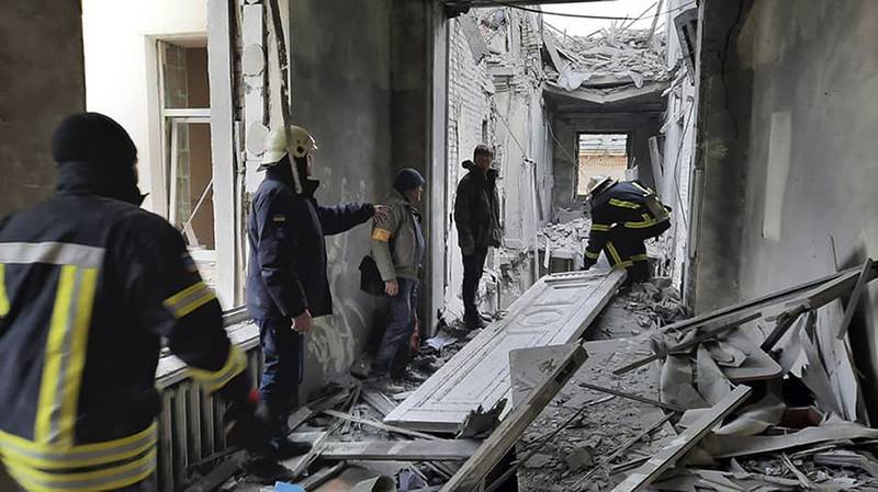 This handout photo released by Ukrainian Emergency Service shows emergency service personnel inspecting the damage inside the City Hall building in Kharkiv, Ukraine, Tuesday, March 1, 2022. Russian shelling pounded civilian targets in Ukraine's second-largest city, Kharkiv, Tuesday and a 40-mile convoy of tanks and other vehicles threatened the capital — tactics Ukraine’s embattled president said were designed to force him into concessions in Europe’s largest ground war in generations. (Ukrainian Emergency Service via AP)