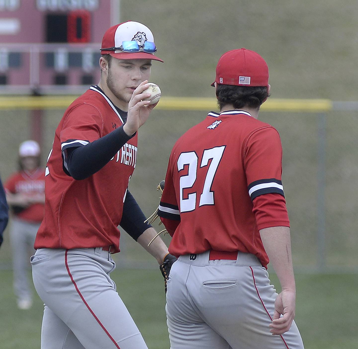 Landon Muntz hands the ball back to team mate pitcher Parker Phillis after Phillis gave up a hit putting two Pirates on base on Thursday, March 30, 2023 at Ottawa High School.