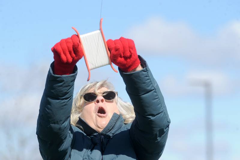 yce Curtin of Lisle reacts, as a stiff wind lifts her kite faster then expected during a celebration of Earth Day and National Kite Month at Prairie Point Park in Oswego, Saturday, April 20, 2024.