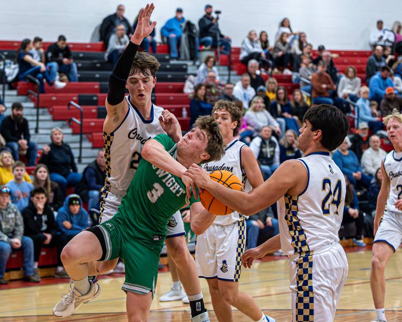 Dwight's Collin Bachand (3) attempts to layup ball but is brought down by Marquette's Griffin Dobberstein (22) and Matthew Graham (24) on Saturday, Feb. 21, 2026 at Marseilles Elementary School.