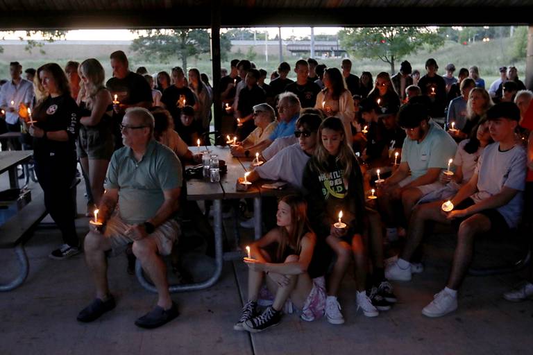 People hold candles during a candlelight celebration for Riely Teuerle on Thursday, August 11, 2022, at Towne Park, 100 Jefferson Street in Algonquin. Teuerle was killed in a car crash in Lake in the Hills on Tuesday. Over 100 family members and friends gathered at the park to remember and celebrate Teuerle’s life.