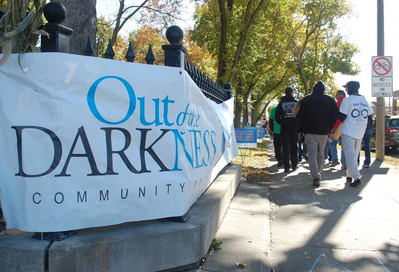 Participants in the Out of the Darkness Community Walk march down La Salle Street alongside Washington Square in downtown Ottawa on Saturday, Oct. 15, 2022. The event honors the memories of people who died by suicide, raises funds for suicide prevention and provides resources for mental health conditions.