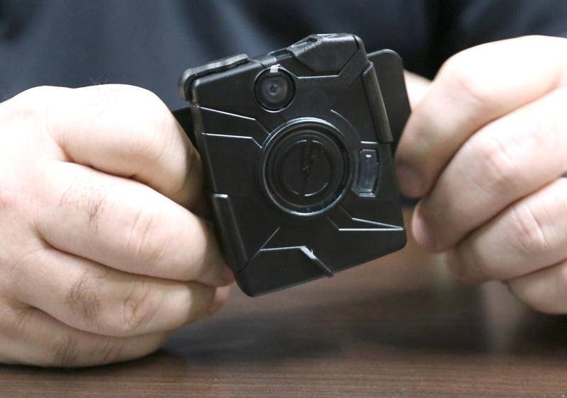 DeKalb Police Commander Craig Woodruff holds one type of body-worn camera in May that the DeKalb Police Department was looking at for a pilot body camera program that was approved for the fiscal 2020 city budget.