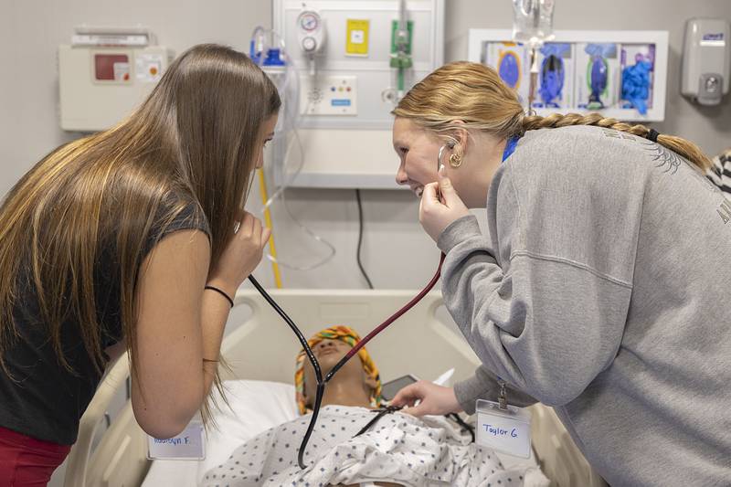 Stillman Valley students Addisyn Faerber (left) and Taylor Grobe use a duo stethoscope Friday, April 17, 2026, learning about SVCC’s health care program. The students were part of ROE’s Health Care Symposium.