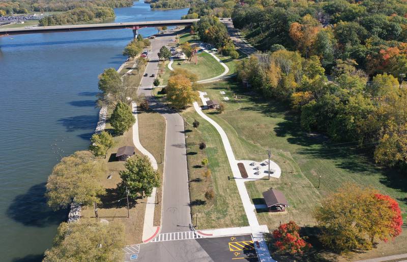 An aerial view of Allen Park during The City of Ottawa ribbon-cutting ceremony on Thursday, Oct. 17, 2024 in Ottawa. Commissioner Marla Pearson (center) cuts the ribbon on a 1.5 million dollar completion of a playground and other improvements to the park. The project was partially funded by a $506,000 IDNR Open Space Land Acquisition and Development grant. The new enhancements to Allen Park include accessible sidewalks leading to the upper plateau, featuring a modern playground and hillside play area with safe, poured-in-place surface for children of all abilities. The area also includes a shelter, bench swing with views of the Illinois River and a stone council ring for relaxation and community gatherings. 
A paved quarter-mile looped walking trail along the scenic banks of the Illinois River, two designated gaming areas, one with four bag toss stations and another with two chess-checkers tables and two ping-pong tables, all designed to promote social interaction and recreation. The sculptures will be repainted in the spring of 2025.