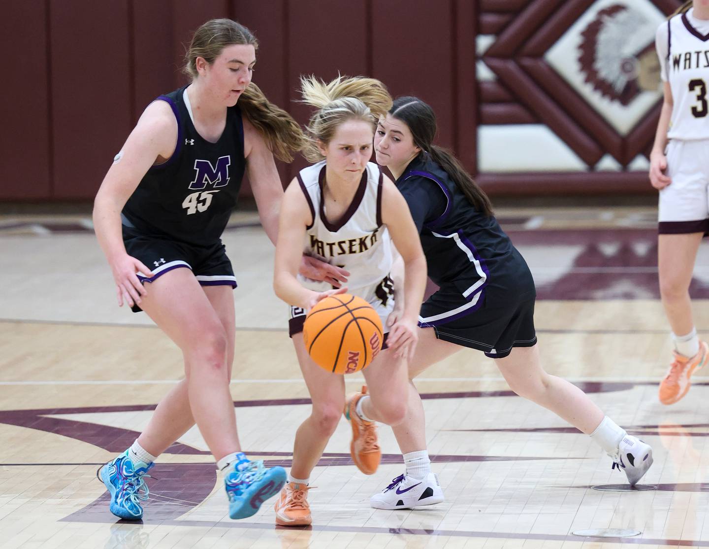 Watseka/Milford's Kami Muehling breaks through Manteno's Emily Horath, left, and Lila Prindeville during Manteno's 57-52 victory on Wednesday, Jan. 21, 2026.