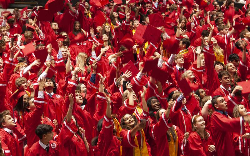 Graduates toss their mortorboards into the air during Yorkville High School's class of 2022 graduation ceremony at the NIU Convocation Center on Friday, May 20, 2022.