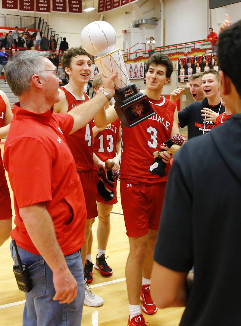 Hinsdale Central's Emerson Eck (3) is handed the championship trophy after the Hinsdale Central Holiday Classic championship game between Oswego East and Hinsdale Central high schools on Thursday, Dec. 29, 2022 in Hinsdale, IL.