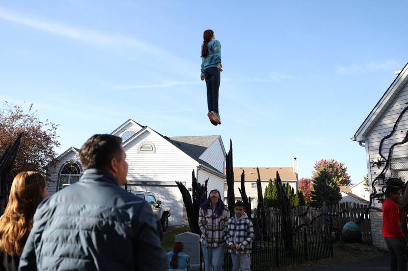 Visitors take pictures at Dave Appel’s Plainfield home with a Halloween display based on the Netflix show "Stranger Things" and featuring a levitating Max character. Video of the display has gone viral on social media. Saturday, Oct. 8, 2022, in Plainfield.