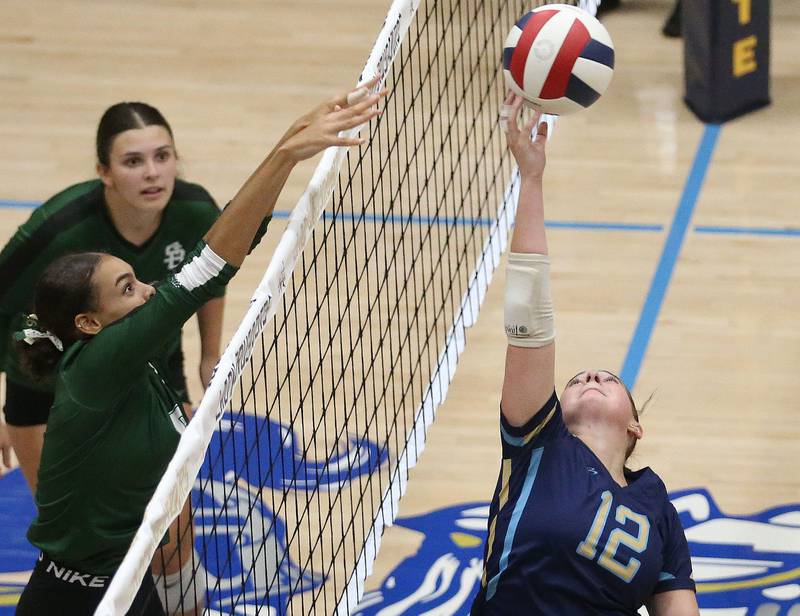 Marquette's Kinley Rick tips the ball in the air as St. Bede's Kijah Lucas sends it over the net on Thursday, Sept. 4, 2025 at Bader Gym.