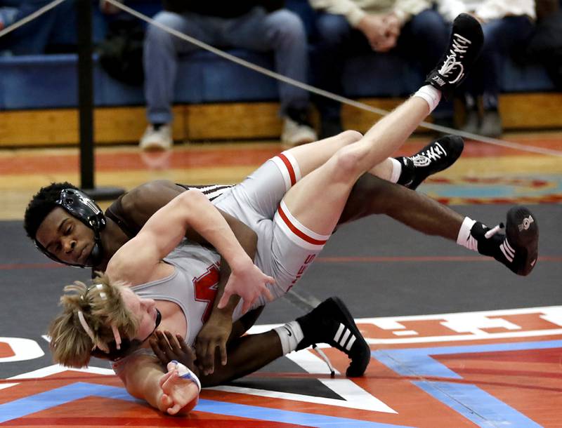 Joliet Catholic's Jason Hampton tries to take down Marian Central's Brayden Teunissen in their 126-pound match during a triangle wrestling meet on Saturday Jan. 11, 2025, between Marian Central, Joliet Catholic, and Mt. Carmel at Marian Central High School in Woodstock.