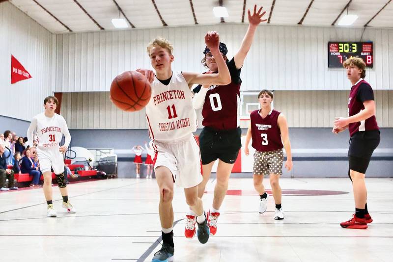 Princeton Christian Academy's Andrew Gibson tries to keep the ball inbounds with Ottawa Christian Academy's Harlyn Hetelle in pursuit Tuesday at Howard Hoffman Memorial Gym. The Eagles won 57-42.