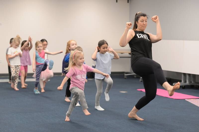 Leah Vaughan of La Grange Park  leads children including Alice Manuel of La Grange Park in an Earth Day Yoga class at La Grange Park Library Sunday April 13, 2025. The class included pretending to be camping and hiking along with pretending to be various animals.