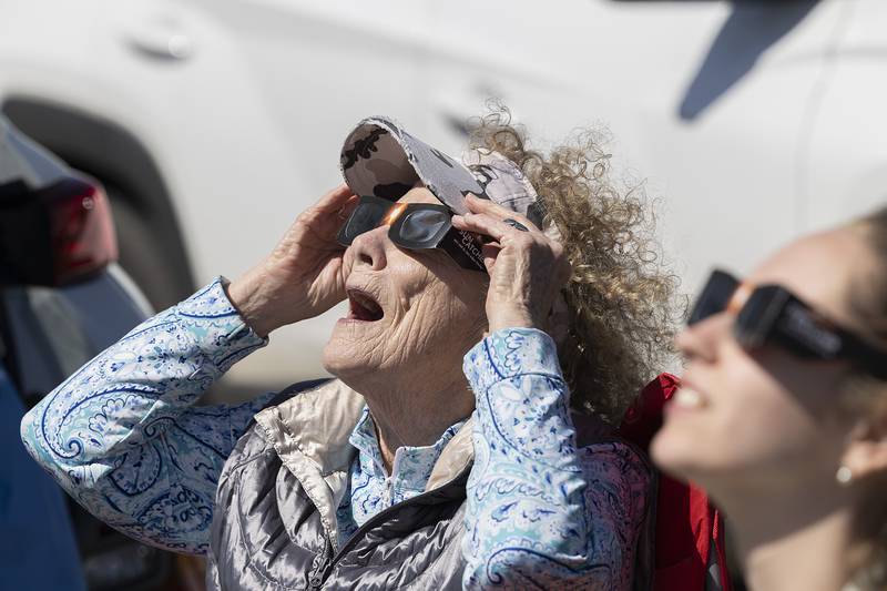 Mary Ristow and granddaughter Hailey Donndelinger of Madison, Wisconsin check out the emerging eclipse Monday, April 8, 2024. The two drove into Dixon for a better viewing of the celestial phenomena and found their way to Sauk Valley Community College.