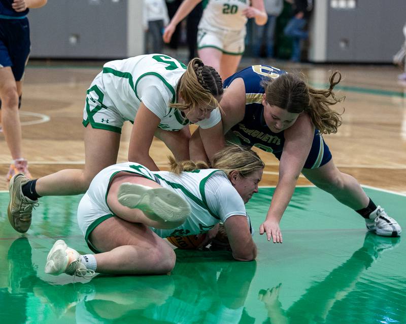 Brynlee Hunt (22) of Seneca lays on top of ball as teammate Kylee Rowlee (15) and Madison Kozlowski (33) of Marquette attempt to grab it on Monday, November 17, 2025 at Seneca High School in Seneca.