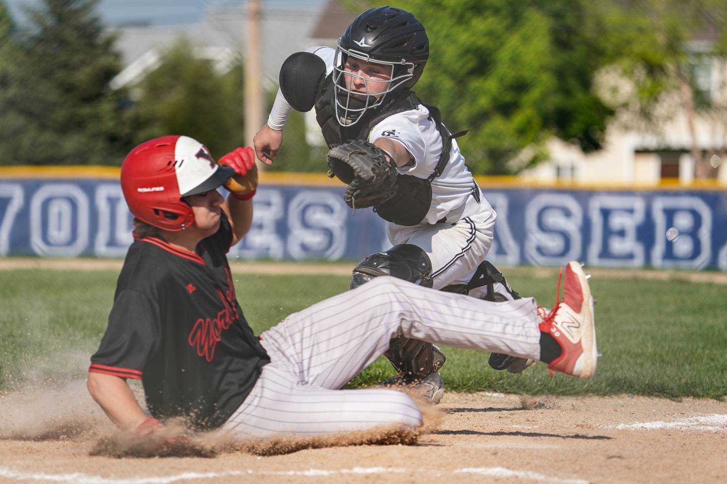 Yorkville's Jacob Cronshaw (8) beats the tag by Oswego East's Christian Martyn (30) to score a run during a baseball game at Oswego East  High School on Monday, May 6, 2024.