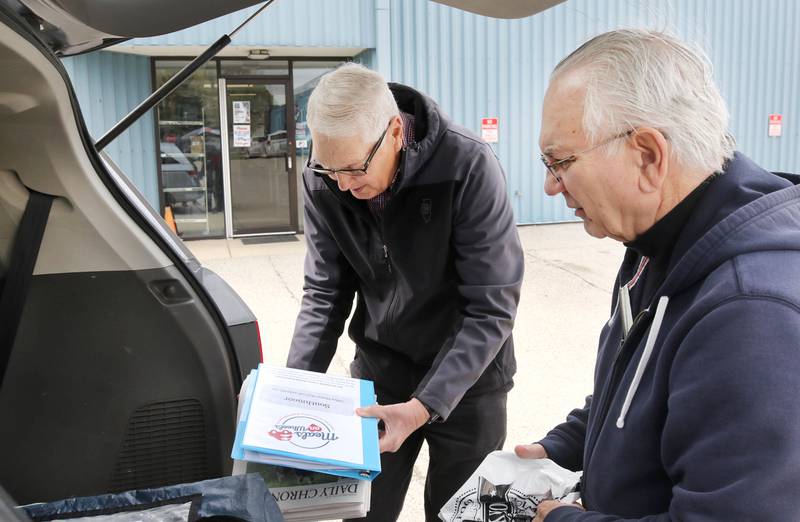 Volunteers Tom Webber (left) and Robert Walters load up their van with a Meals on Wheels delivery Tuesday, April 23, 2024, at the Voluntary Action Center in Sycamore. VAC is celebrating its 50th anniversary this year.