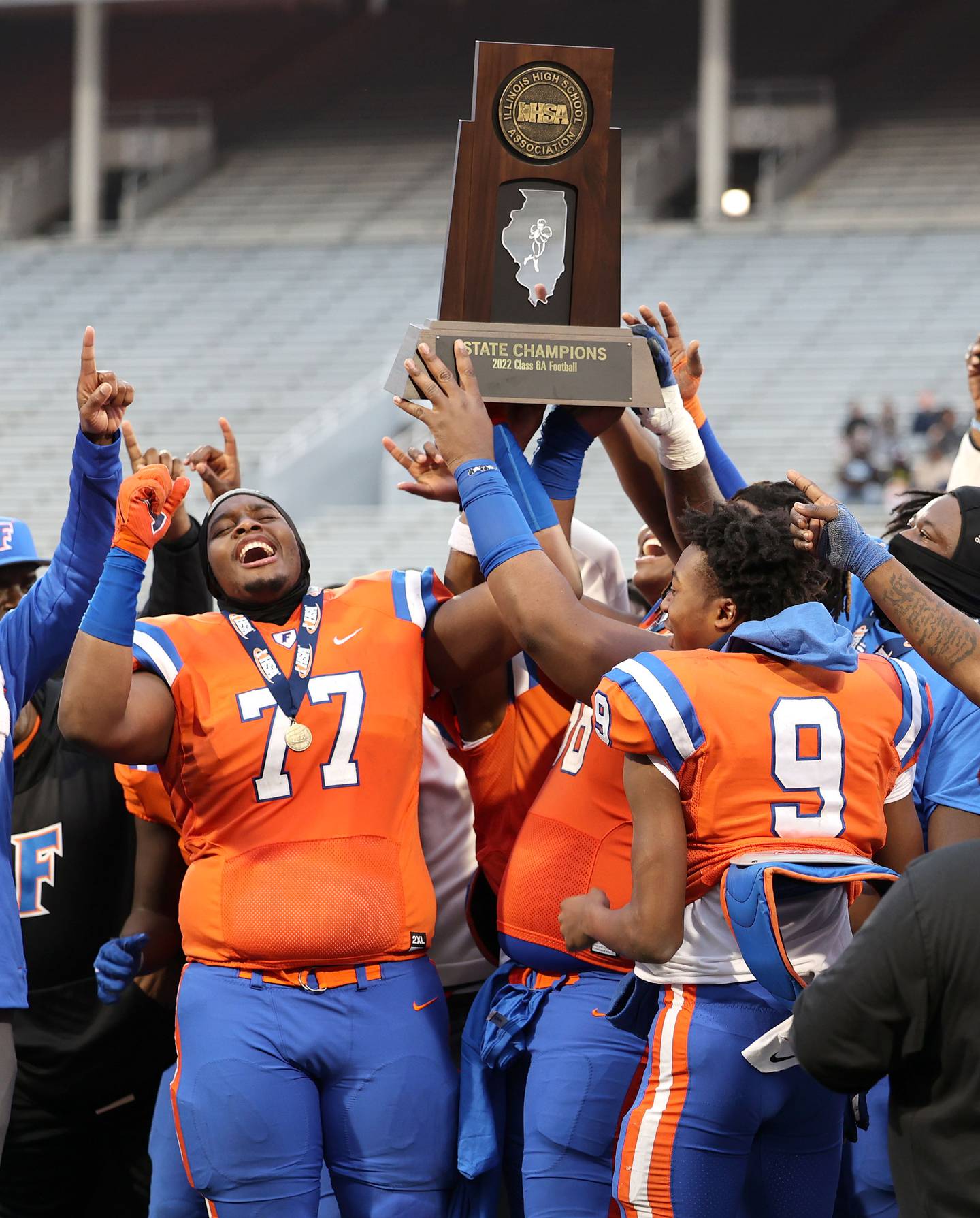 East St. Louis captains accept the trophy after their IHSA Class 6A state championship win over Prairie Ridge Saturday, Nov. 26, 2022, in Memorial Stadium at the University of Illinois in Champaign.