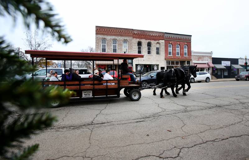 A horse-drawn carriage pulls a wagon of people during the annual Christmas Walk on Saturday, Nov. 23, 2024 on North Main Street in Princeton.