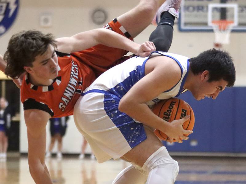 Woodstock’s Ayden Cummings, right, keeps the ball from Sandwich’s Braden Behringer in varsity boys basketball on Tuesday, Feb. 11, 2025, at  Woodstock High School in Woodstock.