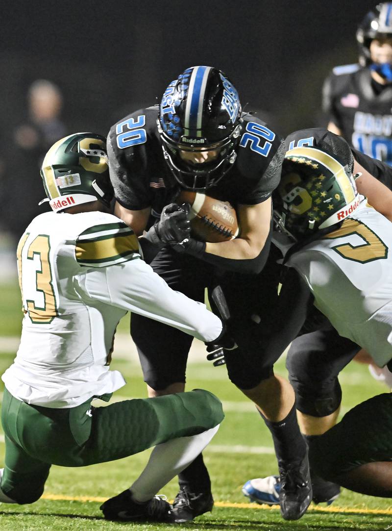 Lincoln-Way East's running back Brody Gish (20) tries to split between Stevenson's Abai (13) and D'Angelo (9) during the IHSA Class 8A Quarterfinals game on Friday, Nov. 15, 2024, at Frankfort. (Dean Reid for Shaw Local News)