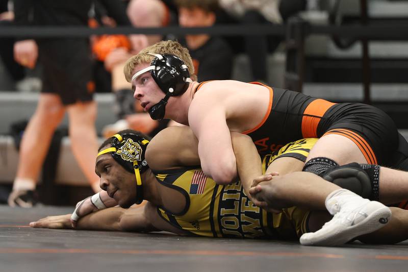 Minooka’s Kaden Meyer works over Joliet West’s Aiden Brown in the SouthWest Prairie Conference 165 pound championship on Saturday, Jan. 24, 2026 in Minooka.