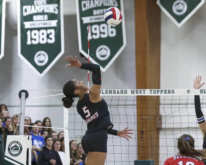 Benet's Brooklynne Brass (5) smashes a kill over the net during Class 4A Glenbard West Sectional final volleyball match between St Charles North at Benet. Nov 6, 2025 in Glen Ellyn.