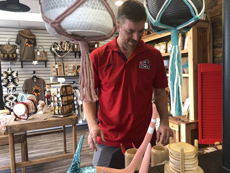 David Badgley, owner of Lumber & Twine, reorganizes a table at Shop 3430. He and the two other retailers sharing the storefront are promoting the first-ever Nightmare on Elm Street ... and Beyond to draw shoppers to downtown McHenry on Oct. 12, 2024.