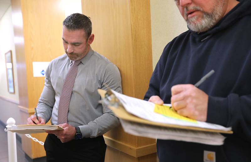McHenry County Sheriff Robb Tadelman (left) fills out a form as he waits in line on Monday, Oct. 27, 2025, to file his paperwork to run for reelection in the Spring 2026 primary.