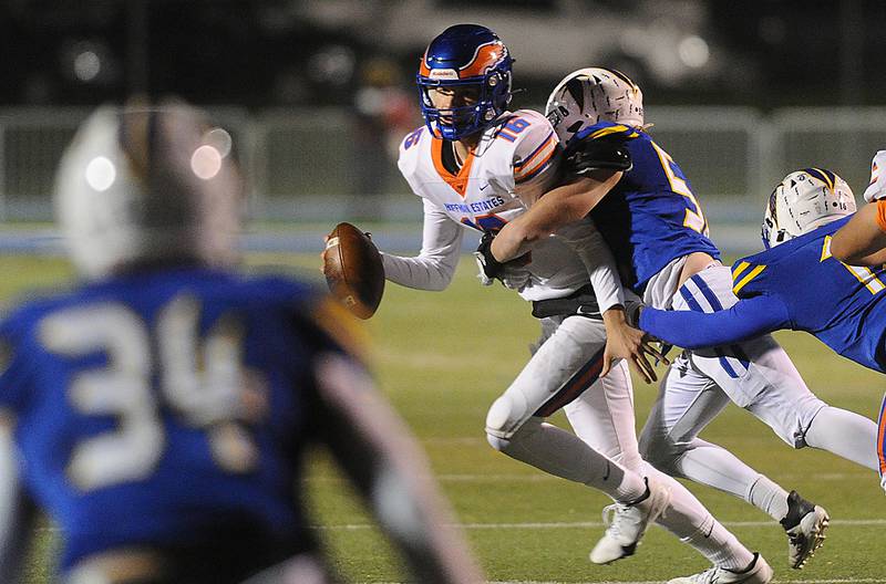 The Hoffman Estates quarterback Aiden Cyr is tackled by Wheaton North's Chuck Neidballa in the boys Class 7A football playoff game in Wheaton on Friday.