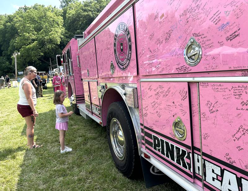Sawyer Schindel, 5, and her mom, Candice, of Tampico, check out the Pink Heals Fire Engine when it showed up at the Rock River Riders Motorcycle Club's Father Day Hill Climb on Sunday, June 15, 2025.