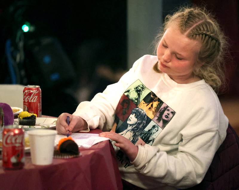 Lilly Haynes, 11, from Sycamore, works a drawing after dinner Wednesday, Nov. 26, 2025, during A World of Thanks, Community Thanksgiving hosted by DeKalb Mutual Aid at the McCabe’s building in DeKalb.