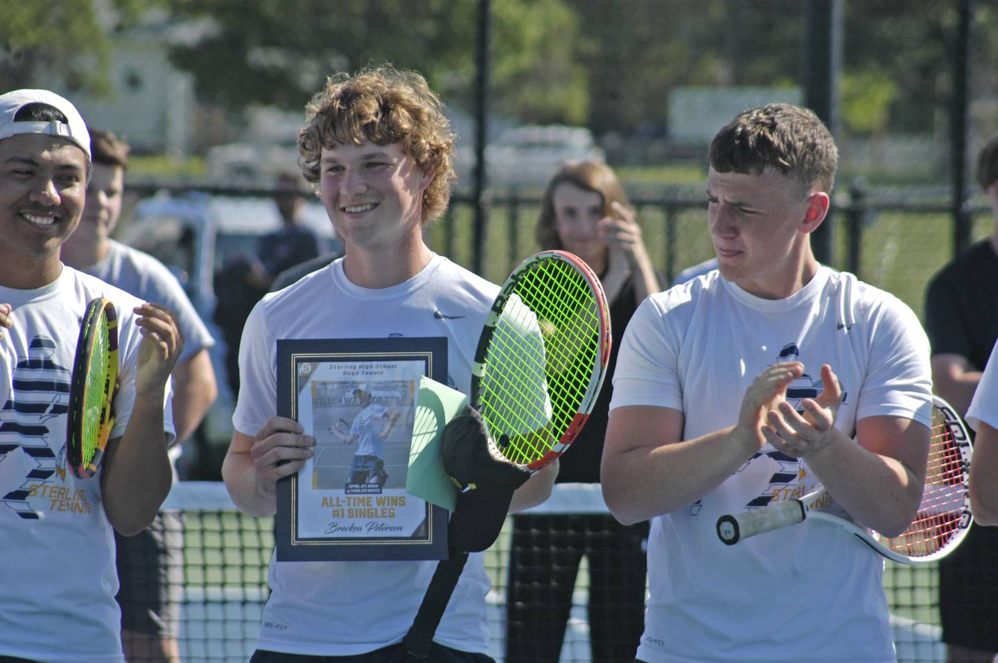 Sterling senior Brecken Peterson holds a plaque presented to him on SHS Tennis Senior Night, Monday, May 6, 2024. Peterson was honored before his final home match as the Golden Warriors' all-time record-holder with 100 wins at No. 1 singles. He broke Tom James' 40-year-old record for career singles victories.
