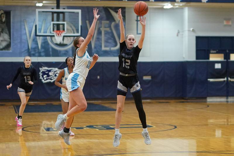Oswego East's Nicole Warbinski (12) shoots a three pointer against Downers Grove South's Addison Bryant (23) during a 4A Oswego East Regional semifinal girls basketball game at Oswego East High School on Monday, Feb 12, 2024.