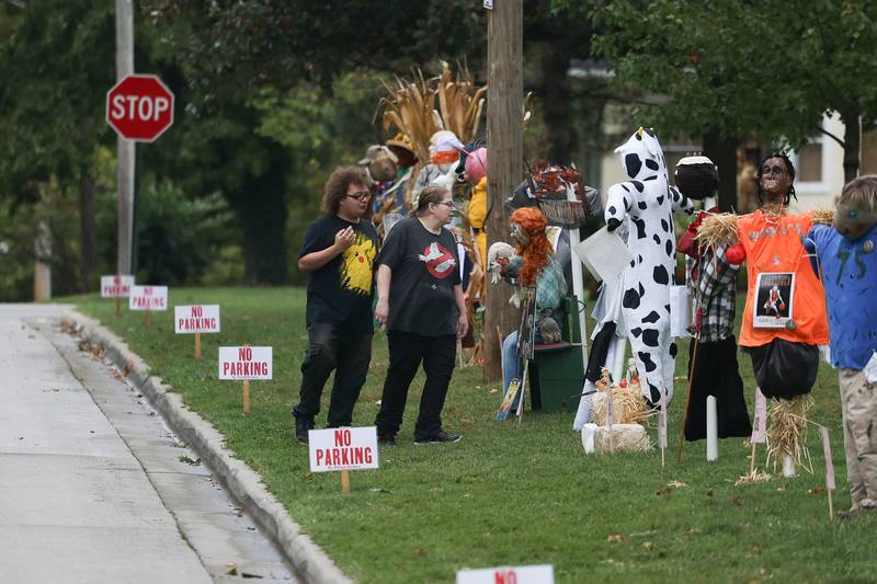A couple checks out the scarecrows lined along the park at the 75th Annual Grundy County Corn Festival on Saturday, Sept. 28, 2024 in downtown Morris.
