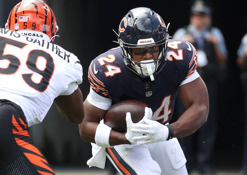 Chicago Bears running back Khalil Herbert looks to run through Cincinnati Bengals linebacker Akeem Davis-Gaither during their August 2024 game at Soldier Field in Chicago.