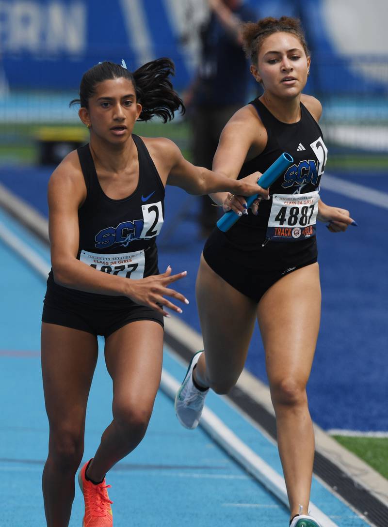 St. Charles North's Alanna Gupta, left, takes the baton from teammate Julia Rodney as the North Stars compete toward a first-place finish in the 3,200-meter relay during the Class 3A girls track and field state meet at Eastern Illinois University on Saturday, May 23, 2026 in Charleston.