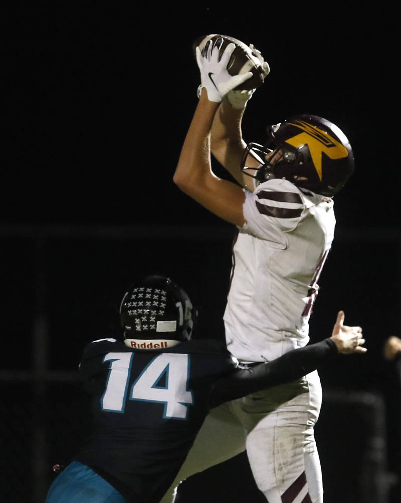 Richmond-Burton's Luke Robinson catches a touchdown pass over Woodstock North's Conlan Leese during a Kishwaukee River Conference football game on Friday, Oct. 10, 2025, at Woodstock North High School.
